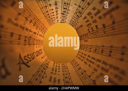 Fotoidee mit Notenblättern gerollt und transparent. Abstrakt und künstlerisch dargestellt Stockfoto