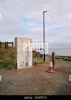 Spaceman Graffiti-Kunstwerk Wandbild auf einem geretteten Stück Wand atmen Meeresluft am Strand in Skinningrove Cleveland Yorkshire England Großbritannien Stockfoto