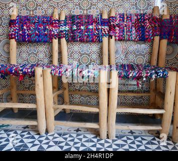 Nahaufnahme von traditionellen handgefertigten marokkanischen Stühlen mit farbenfrohem Mosaik in einem Berber-Haus. Hohes Atlasgebirge, Marokko. Stockfoto