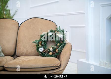 Schöne gemütliche Wohnung mit einem natürlichen Weihnachtsbaum für Weihnachten dekoriert. Natürlicher Weihnachtskranz. Skandinavische Innenausstattung. Stockfoto