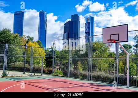 Basketballplatz mit den 5 Wolkenkratzern der Stadt Madrid in Spanien. Europa. Horizontale Fotografie. Stockfoto