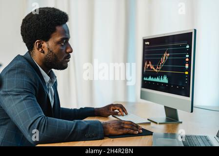 Konzentrierter schwarzer Mann Handel online auf binäre Option Stockfoto