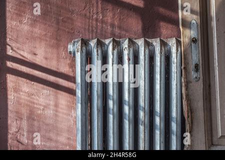 Alte gusseiserne Heizkörper im Grunge-Stil. Heizkonzept Winterhaus. Stockfoto