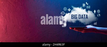 Geschäftsmann hält die Inschrift , Wort BIG DATA . Vorhängeschloss, Gehirn, Mann, Planet, Graph, Lupe, Zahnräder, Symbol für Cloud, Grid, Dokument, Brief, Telefon Stockfoto