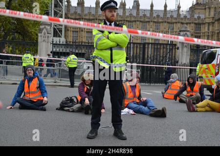 London, Großbritannien. November 2021. Isolieren Sie britische Aktivisten, indem sie Straßen um das Parlament herum blockieren, indem sie sich an die Straßen kleben. Quelle: Thomas Krych/Alamy Live News Stockfoto