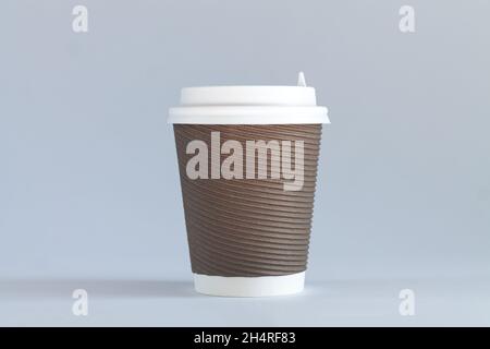 Eine braune Einweg-Kaffeetasse aus Papier mit weißen Kappen in Nahaufnahme. Konzept zum Mitnehmen Stockfoto