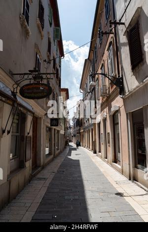 Koper, Slowenien - 12. Juli 2021: Enge Gassen zwischen Mietshäusern in der Altstadt. Alte Gebäude in einer Hafenstadt an der Adria. Stockfoto