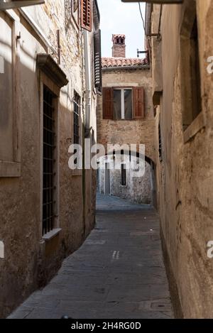 Koper, Slowenien - 12. Juli 2021: Enge Gassen zwischen Mietshäusern in der Altstadt. Alte Gebäude in einer Hafenstadt an der Adria. Stockfoto