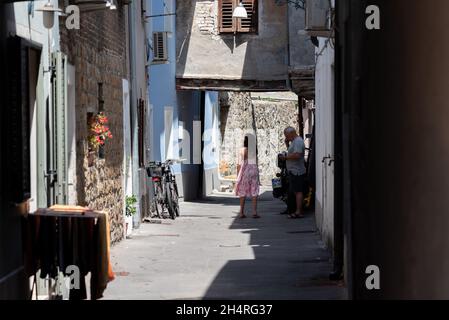 Koper, Slowenien - 12. Juli 2021: Enge Gassen zwischen Mietshäusern in der Altstadt. Alte Gebäude in einer Hafenstadt an der Adria. Stockfoto