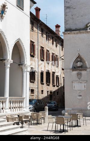 Koper, Slowenien - 12. Juli 2021: Enge Gassen zwischen Mietshäusern in der Altstadt. Alte Gebäude in einer Hafenstadt an der Adria. Stockfoto