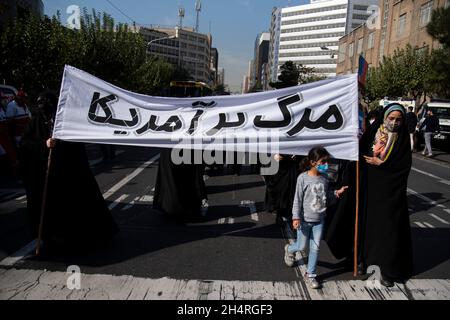 Teheran, Iran. November 2021. Demonstranten halten bei einer Kundgebung vor der ehemaligen US-Botschaft ein Anti-USA-Transparent ab, um an den Jahrestag ihrer Festnahme 1979 in Teheran, Iran, am Donnerstag, den 4. November 2021, zu erinnern. Die Übernahme der Botschaft löste eine 444-tägige Geiselkrise und einen Bruch der diplomatischen Beziehungen aus, die bis heute andauert. (Foto: Sobhan Farajvan/Pacific Press/Sipa USA) Quelle: SIPA USA/Alamy Live News Stockfoto