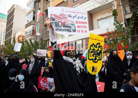 Teheran, Iran. November 2021. Ein Demonstrator hält ein Anti-US-Plakat bei einer Kundgebung vor der ehemaligen US-Botschaft, die an den Jahrestag ihrer Festnahme 1979 in Teheran, Iran, am Donnerstag, den 4. November 2021 erinnert. Die Übernahme der Botschaft löste eine 444-tägige Geiselkrise und einen Bruch der diplomatischen Beziehungen aus, die bis heute andauert. (Foto: Sobhan Farajvan/Pacific Press/Sipa USA) Quelle: SIPA USA/Alamy Live News Stockfoto