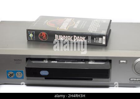 HUELVA, SPANIEN - 11. Oktober 2021: Die VHS-Filmkassette des Jurassic Park auf einem alten Sony-Videorecorder, isoliert auf weißem Hintergrund Stockfoto