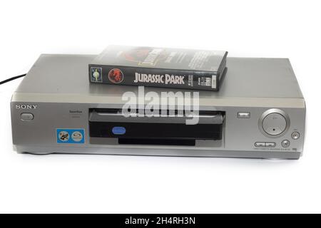 HUELVA, SPANIEN - 11. Oktober 2021: Die VHS-Filmkassette des Jurassic Park auf einem alten Sony-Videorecorder, isoliert auf weißem Hintergrund Stockfoto