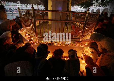 Amritsar, Amritsar des nördlichen indischen Bundesstaates Punjab. November 2021. Menschen zünden Kerzen und Lampen am Goldenen Tempel an anlässlich des Diwali, dem Lichterfest, in Amritsar im nördlichen indischen Bundesstaat Punjab, 4. November 2021. Quelle: Str/Xinhua/Alamy Live News Stockfoto