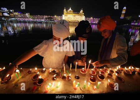 Amritsar, Amritsar des nördlichen indischen Bundesstaates Punjab. November 2021. Menschen zünden Kerzen und Lampen am Goldenen Tempel an anlässlich des Diwali, dem Lichterfest, in Amritsar im nördlichen indischen Bundesstaat Punjab, 4. November 2021. Quelle: Str/Xinhua/Alamy Live News Stockfoto