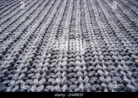 Die Textur einer grauen Strickjacke aus Wolle, Pullover. Stockfoto
