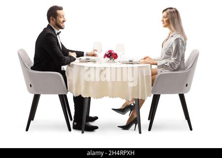 Junge elegante Mann und Frau sitzen an einem Restauranttisch isoliert auf weißem Hintergrund Stockfoto