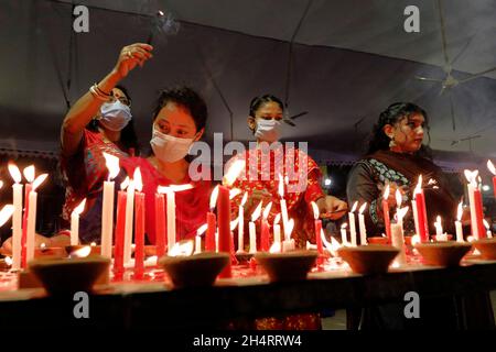 NOVEMBER04,2021,DHAKA-BANGLADESH- Anhänger sahen am 4. November 2021 im Dhakeshwari-Tempel in Dhaka, Bangladesch, Kerzen anzünden, als sie an einem Fest zur Feier von Diwali, dem hinduistischen Fest des Lichts, teilnahmen. Stockfoto