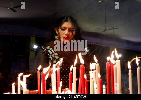 NOVEMBER04,2021,DHAKA-BANGLADESH- Anhänger sahen am 4. November 2021 im Dhakeshwari-Tempel in Dhaka, Bangladesch, Kerzen anzünden, als sie an einem Fest zur Feier von Diwali, dem hinduistischen Fest des Lichts, teilnahmen. Stockfoto