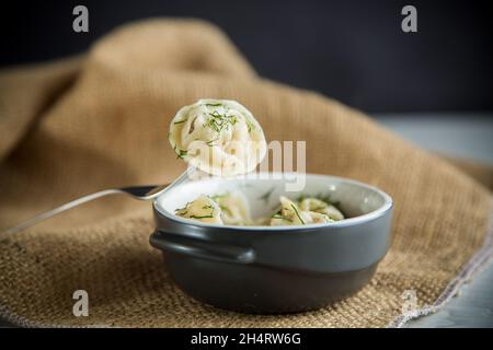 Gekochte Knödel mit Fleischfüllung in einer Schüssel auf dem Tisch Stockfoto