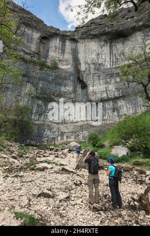 Malham Cove, im Sommer sehen Sie Menschen, die Malham Cove besuchen, eine Klippe aus dem Jahr 260ft in Malhamdale, einer Gegend von herausragender natürlicher Schönheit in Yorkshire, Großbritannien Stockfoto