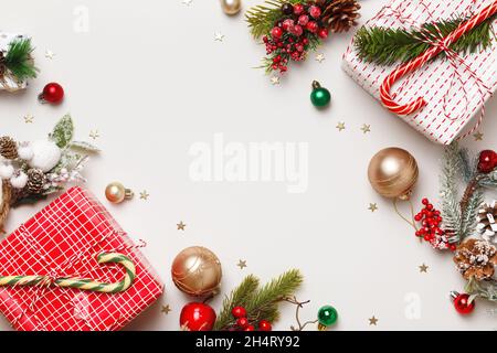 Neujahrswinterkomposition. Weihnachtskisten mit Kugeln aus Tannenzweigen von Geschenken auf grauem Hintergrund. Rahmen Rahmen flach Lay Draufsicht Kopieplatz Stockfoto
