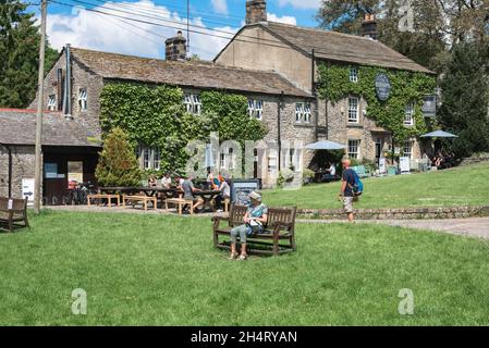 Pub Yorkshire, Blick im Sommer auf Menschen, die vor dem Lister Arms sitzen, einem beliebten historischen Gasthaus im Zentrum von Malham Village, Yorkshire Dales, Großbritannien Stockfoto