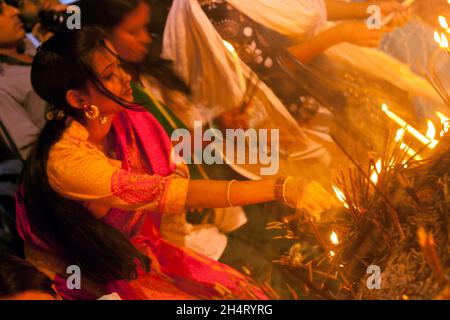 NOVEMBER04,2021,DHAKA-BANGLADESH- Anhänger sahen am 4. November 2021 im Dhakeshwari-Tempel in Dhaka, Bangladesch, Kerzen anzünden, als sie an einem Fest zur Feier von Diwali, dem hinduistischen Fest des Lichts, teilnahmen. Stockfoto