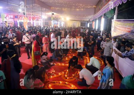 NOVEMBER04,2021,DHAKA-BANGLADESH- Anhänger sahen am 4. November 2021 im Dhakeshwari-Tempel in Dhaka, Bangladesch, Kerzen anzünden, als sie an einem Fest zur Feier von Diwali, dem hinduistischen Fest des Lichts, teilnahmen. Stockfoto