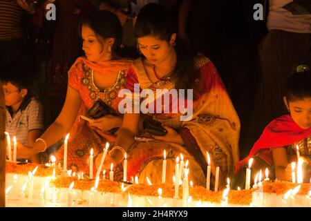 NOVEMBER04,2021,DHAKA-BANGLADESH- Anhänger sahen am 4. November 2021 im Dhakeshwari-Tempel in Dhaka, Bangladesch, Kerzen anzünden, als sie an einem Fest zur Feier von Diwali, dem hinduistischen Fest des Lichts, teilnahmen. Stockfoto