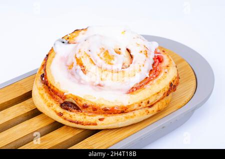 Süßes Brötchen mit Rosinen und weißer Zuckereierung. Studio Photo Stockfoto