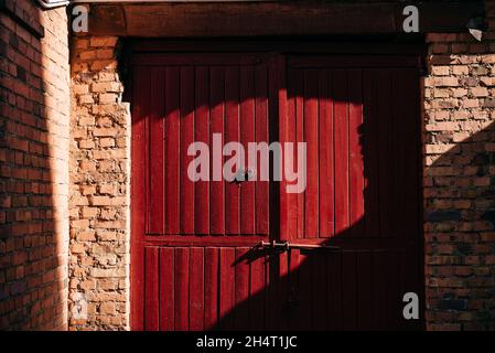 Alte rote Holztüren in einem Backsteingebäude Stockfoto