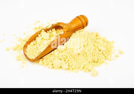 Haufen Maismehl mit Schaufel auf weißem Hintergrund. Studio Photo Stockfoto