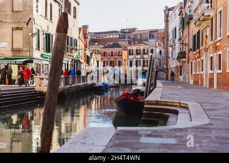 VENEDIG, ITALIEN - 27. OKTOBER 2016: Touristen entspannen sich in einem ruhigen, schönen Kanal in Venedig, Italien Stockfoto