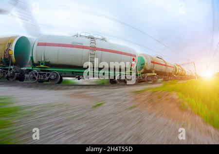 Zug mit Öltanks zu bewegen. Transport von Kraftstoff, der auf der Eisenbahn. Bewegungsunschärfe. Stockfoto