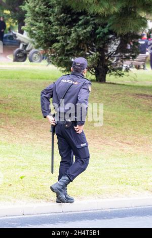 Huelva, Spanien - 30. Oktober 2021: Rückansicht der spanischen Nationalpolizei mit 'Policia'-Logo-Emblem auf Uniform, Aufrechterhaltung der öffentlichen Ordnung in den Straßen o Stockfoto