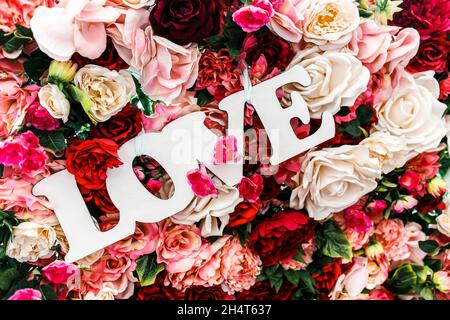 „Love“-Schild, umgeben von Blumen. Stockfoto
