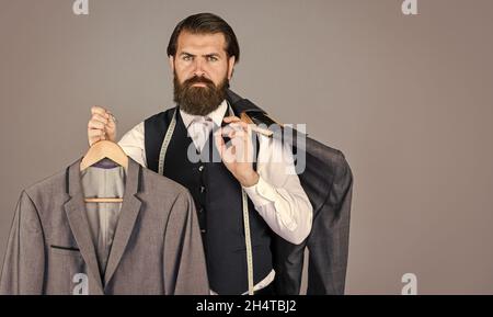 Bärtiger Mann Schneiderbekleidung. Formelle und Büro Garderobe. Geschäftsmann. Zuversichtlich Schneider Gestaltung männliche Jacke. Schöner sartor mit Maßband Stockfoto