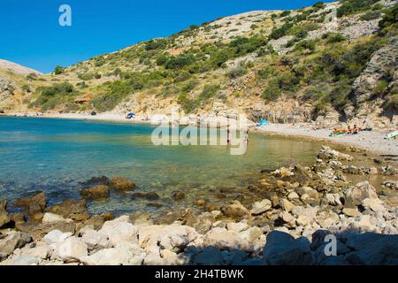 Stara Baska, Kroatien - 6. September 2021. Touristen und Einheimische genießen einen abgeschiedenen Strand an der zerklüfteten Küste nördlich von Stara Baska im Süden von Krk Stockfoto