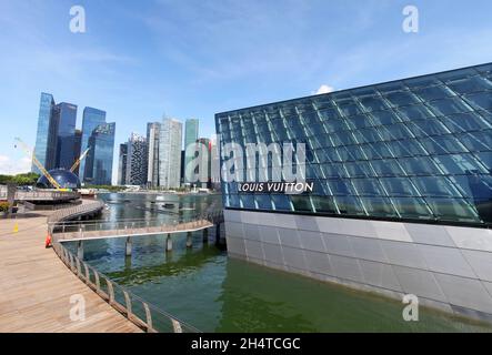 Das Louis Vuitton Geschäft mit moderner Glas- und Stahlkonstruktion in Marina Bay Sands liegt im Wasser der Bucht in Singapur. Stockfoto