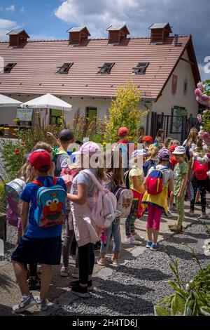 Wojslawice, Polen - 09. Juli 2021: Eine Gruppe farbenfroher Schulkinder, die in einer Schlange am Eingang eines botanischen Gartens stehen. Stockfoto