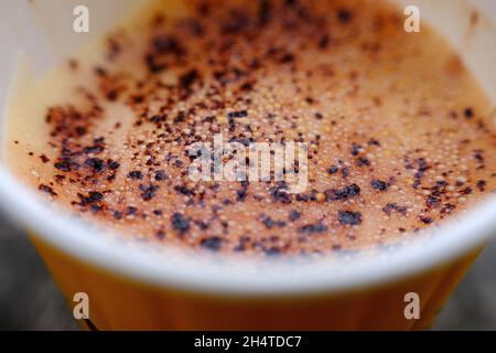 Eine Nahaufnahme von Cappucchino-Schaum mit Schokoladenstreuseln in einem Becher. Stockfoto