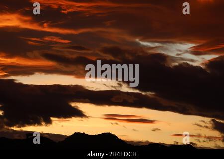 Dramatischer Sonnenuntergang über den Bergen und Farbenexplosion. Stockfoto