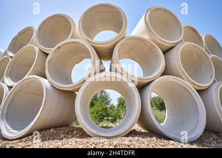 Stapel von Entwässerungsbetonrohr für Klärgruben und Brunnen. Stockfoto