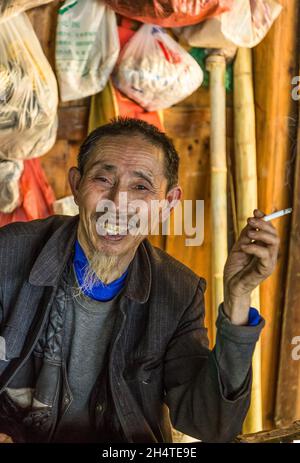 Ein älterer Chinese, der traditionelle pflanzliche Arzneimittel im Zhangjiajie National Forest Park in China verkauft. Stockfoto