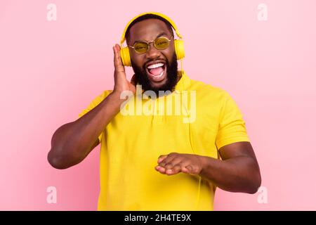 Foto von afro amerikanischen glücklich verrückten Mann tragen Headset dj Musik Liebhaber genießen Song isoliert auf rosa Hintergrund Stockfoto