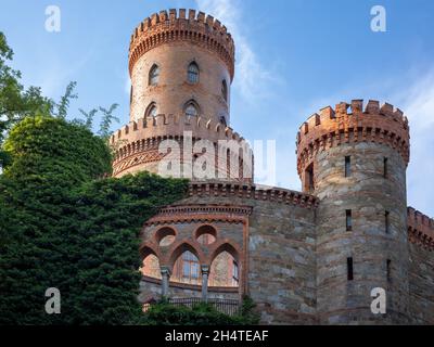 Kamieniec Zabkowicki, Polen - 4. Juli 2021: Türme des neugotischen Kamieniec Zabkowicki-Palastes. Blauer Himmel, sonniger Tag. Stockfoto