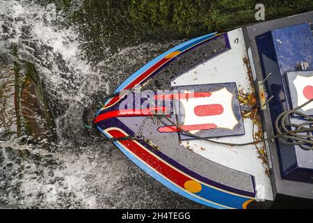 Draufsicht auf das Vorderende eines isolierten Schmalbootes in einer britischen Kanalschleuse, da es sich mit Wasser füllt. Stockfoto