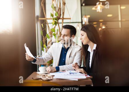 Arbeitskonzept. Junge Kollegen arbeiten an neuen Plänen und machen Berechnungen im modernen Büro Stockfoto